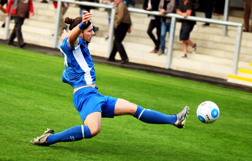 football player stretches for the ball