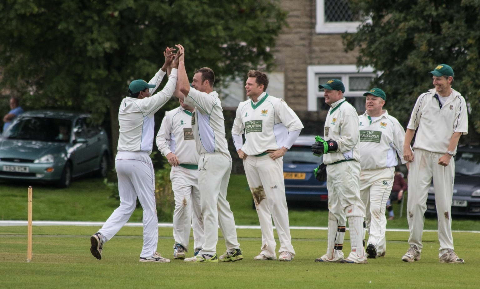 cricket team have a discussion on the pitch